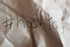 Hand writen hashtag on crumpled kraft paper